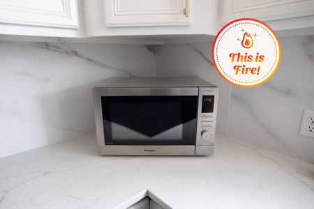 Panasonic HomeChef 4-in-1 Microwave Oven with Air Fryer displayed on a marbled counter below wooden cupboards 