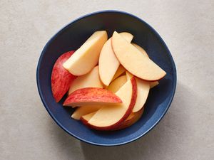 A blue bowl with sliced apples