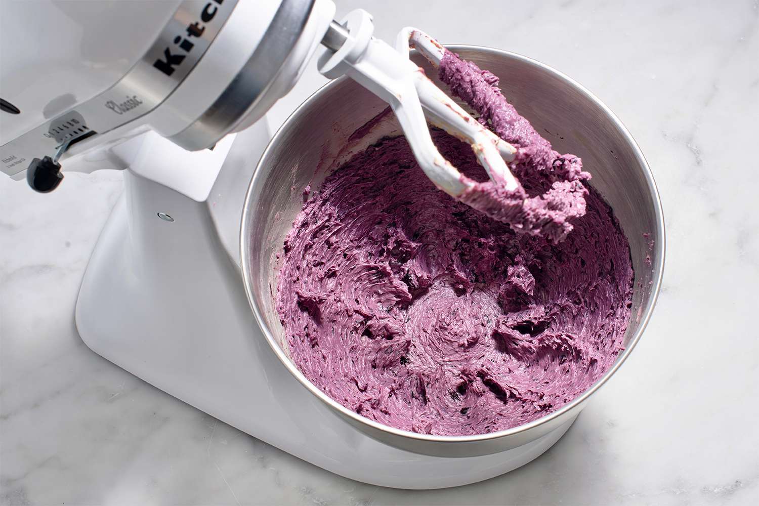 Batter with blueberries, baking powder, and salt in a stand mixer 