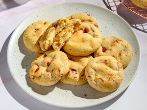 A plate of strawberry cheesecake cookies, with one ripped open showing a cream cheese center