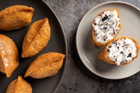 Rice Stuffed Tofu Pockets (Inari Sushi) on two plates