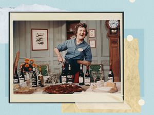 Julia child opening wine at a table