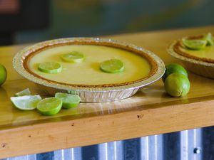 Key lime pie and limes on countertop, close-up