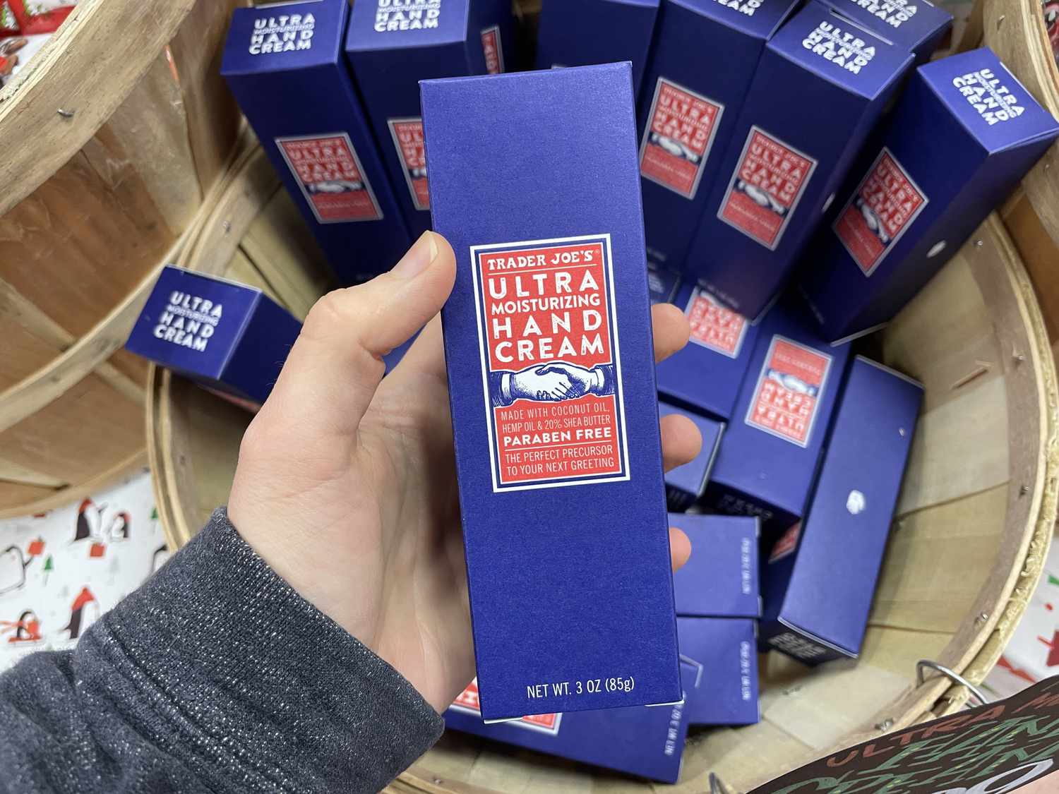 A hand holding a box of Trader Joe's ultra moisturizing hand cream