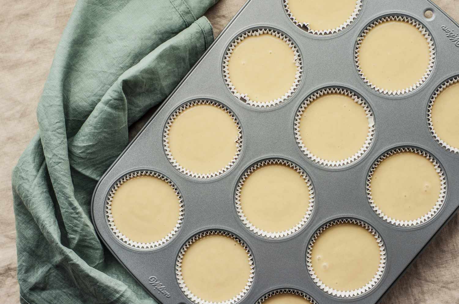 Spoon muffin mixture into muffin baking sheet