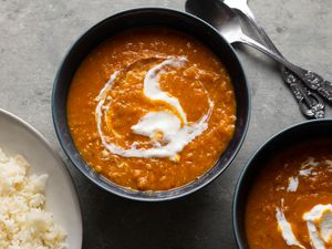 Spicy vegan lentil dahl in bowls with dollops of soy yogurt