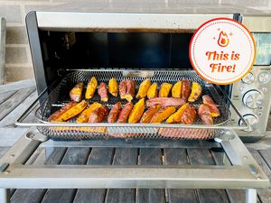 Breville Toaster Convection Air Fryer Oven with cooked sweet potato wedges displayed on a wooden table