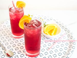 Jolly Rancher cocktails garnished with orange wedges