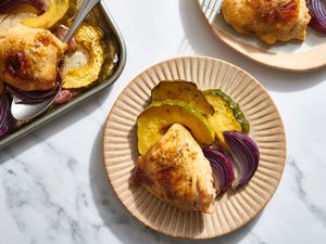 A serving of sheet pan maple garlic chicken with a sheet pan of chicken and vegetables