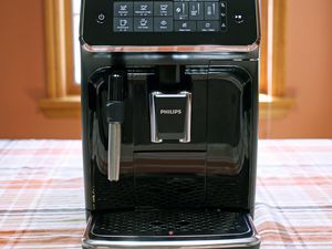 Philips Series 3200 Fully Automatic Espresso Machine displayed on a plaid tablecloth in front of a window