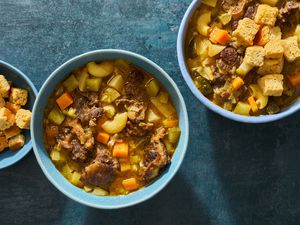 Three bowls of soup joumou (Haitian freedom soup), garnished with croutons