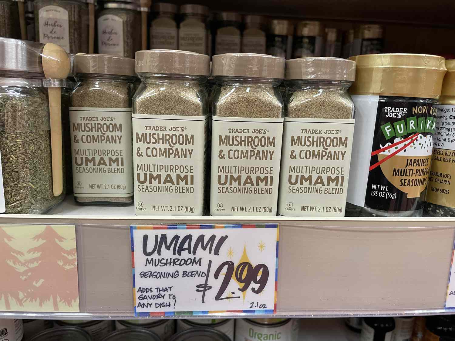 Trader Joe's Mushroom & Company multipurpose umami mushroom seasoning blend in glass spice bottles on a shelf with a $2.99 price tag