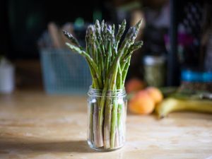 Raw asparagus spears standing in a jar