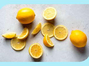 Whole and sliced lemons on a stone or concrete surface