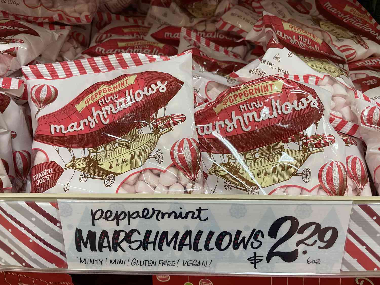 Bags of Trader Joe's peppermint mini marshmallows on a shelf with a $2.29 price tag