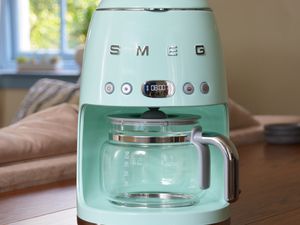 Smeg Drip Coffee Machine displayed on a wooden table