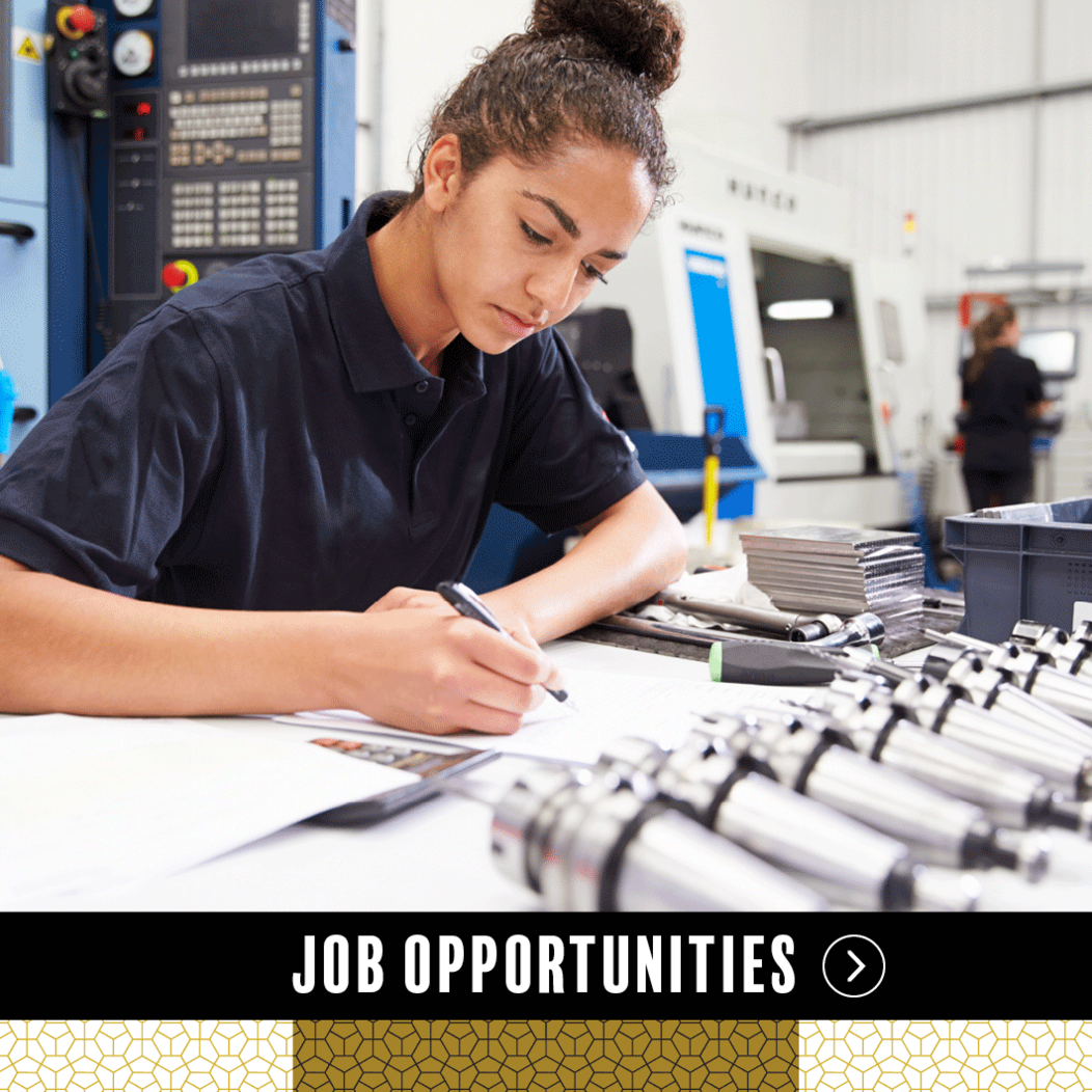 A woman sitting at a table in a technical lab, representing Job Opportunities in Waterbury CT