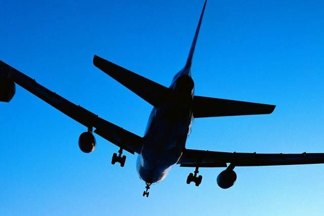 An aeroplane in mid-flight in a blue sky.