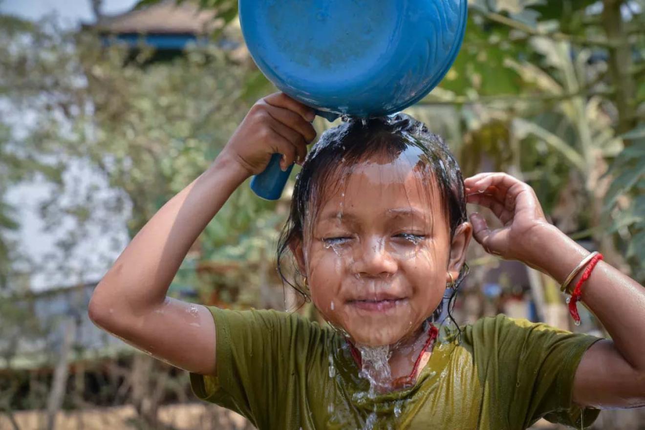 child pouring water on itself