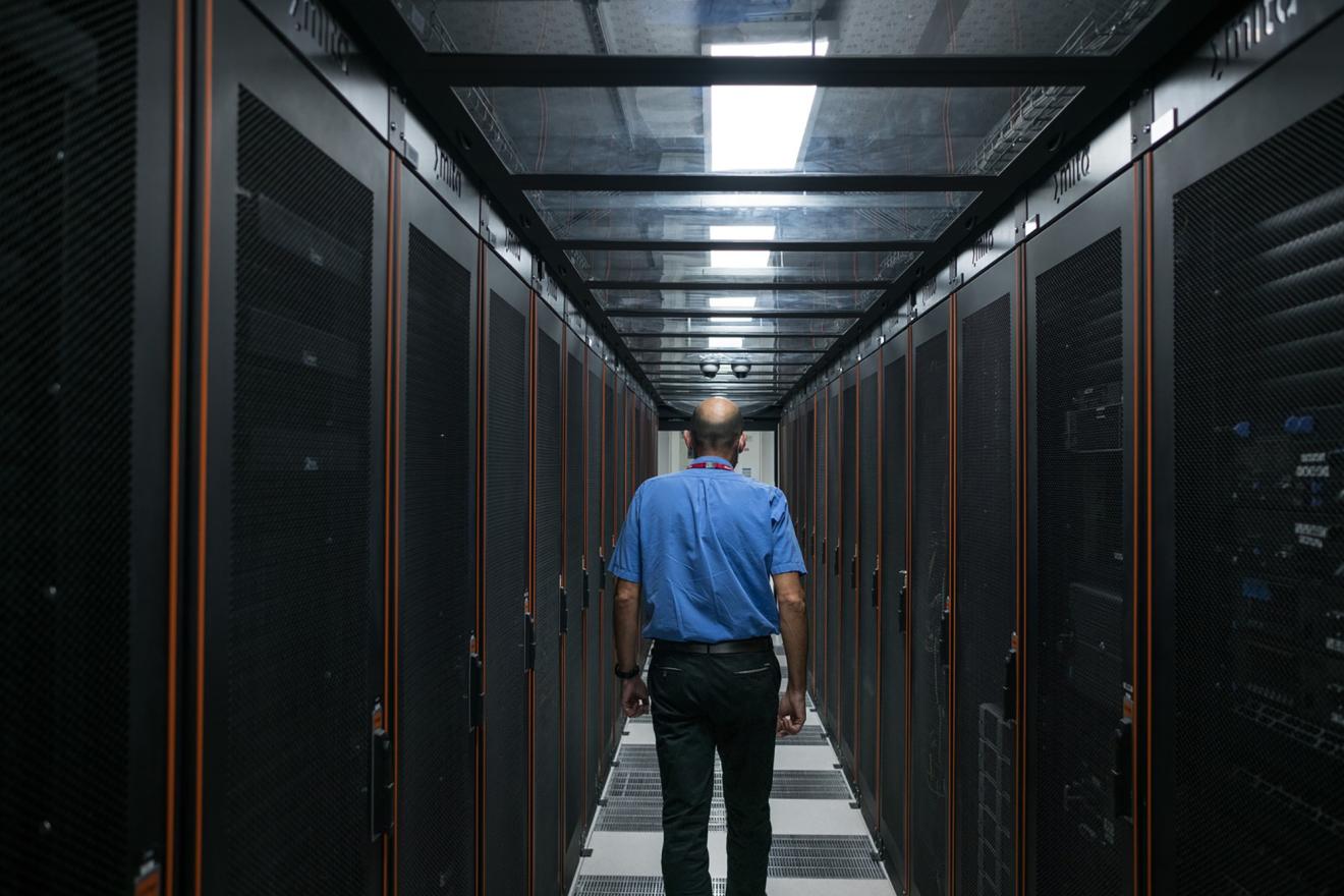 Un hombre camina entre dos columnas de servidores de Internet.