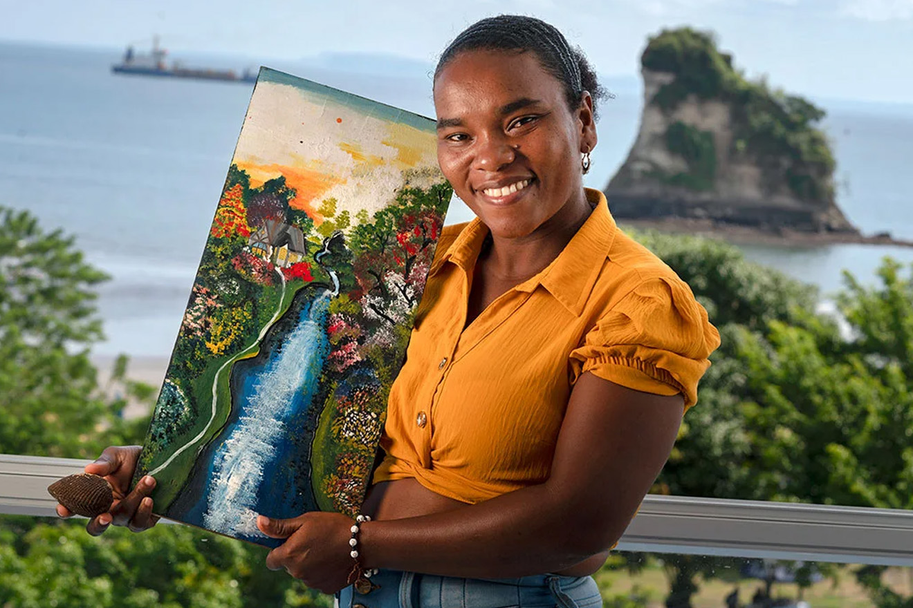 A woman displays a piangua, the shelled mollusk she harvests artisinally in Tumaco, and a painting representing the estuaries full of mangroves