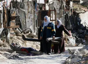 Women salvage usable materials from damaged parts of Al-Hatab Square in the old quarter of Aleppo, northern Syria, February 2017. Photo: EPA/Youssef Badawi