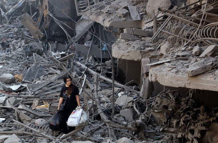 On 29 September 2024 a woman in Beirut, Lebanon walks among the debris of buildings destroyed by airstrikes.