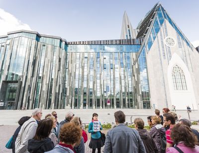 Foto: eine Gästegruppe mit Führerin steht auf dem Augustusplatz mit Blick auf das Paulinum