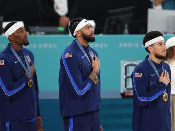 Three former UK Men's Basketball Players Standing on the Podium Receiving Gold Medals