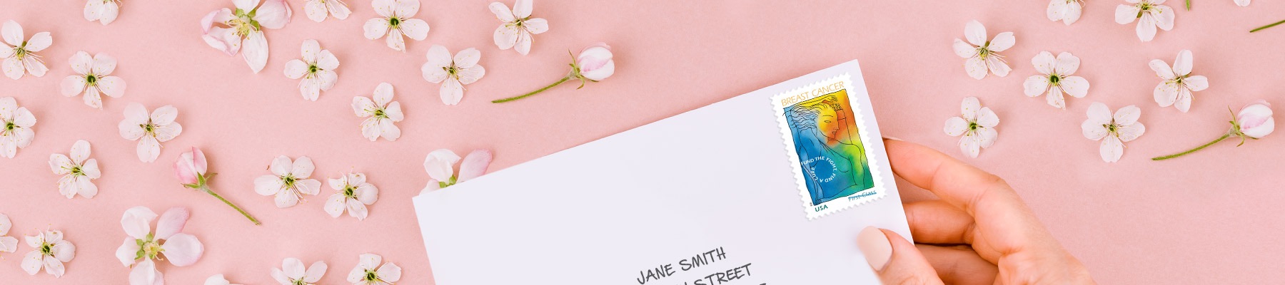 An envelope with a Breast Cancer Research semipostal stamp on a pink background.