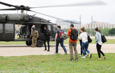 People walking toward helicopter with backpacks on