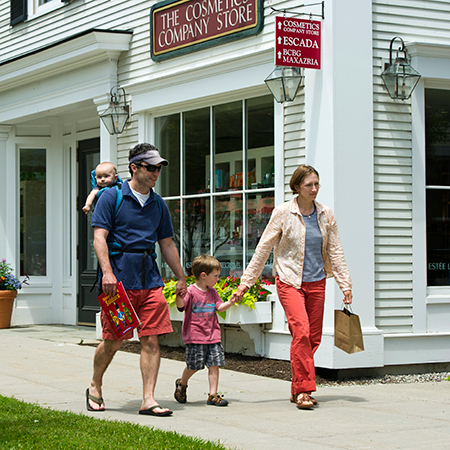 Family of four walking through a town exploring and shopping.