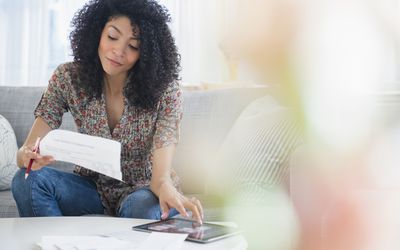 Woman is paying bills using her net pay, what is left after deductions are made by her employer.