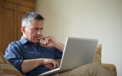 Man using laptop on sofa