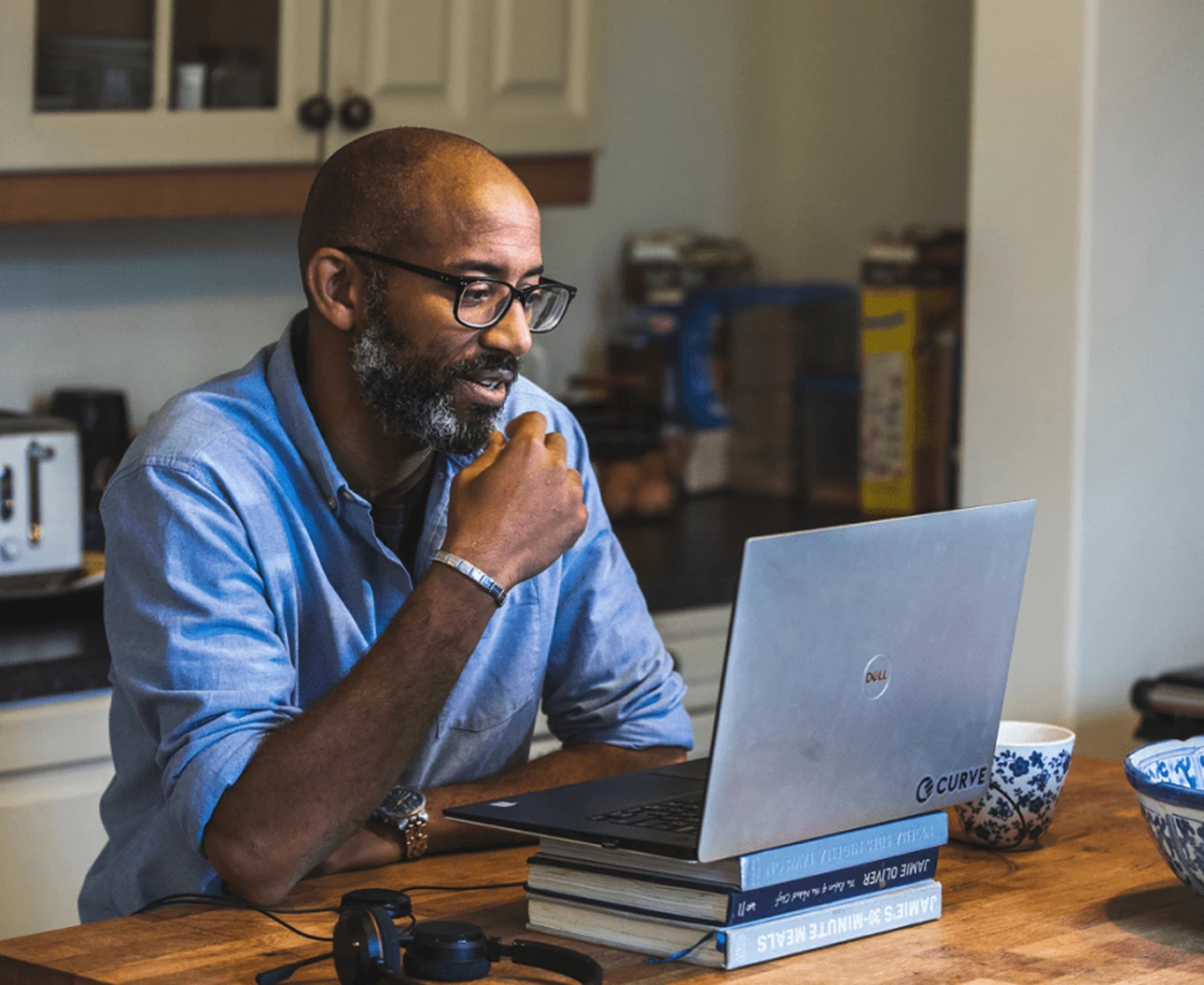 30 year old male customer experience expert working from home looking at his laptop