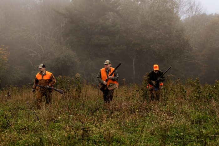 A photo of three men in blaze and camo hunting in West Virginia