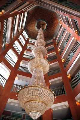 This is looking up in the atrium of a hotel at a massive chandelier