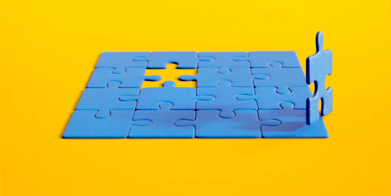 An animated puzzle piece jumps out of a puzzle, then circles back to rejoin the puzzle.