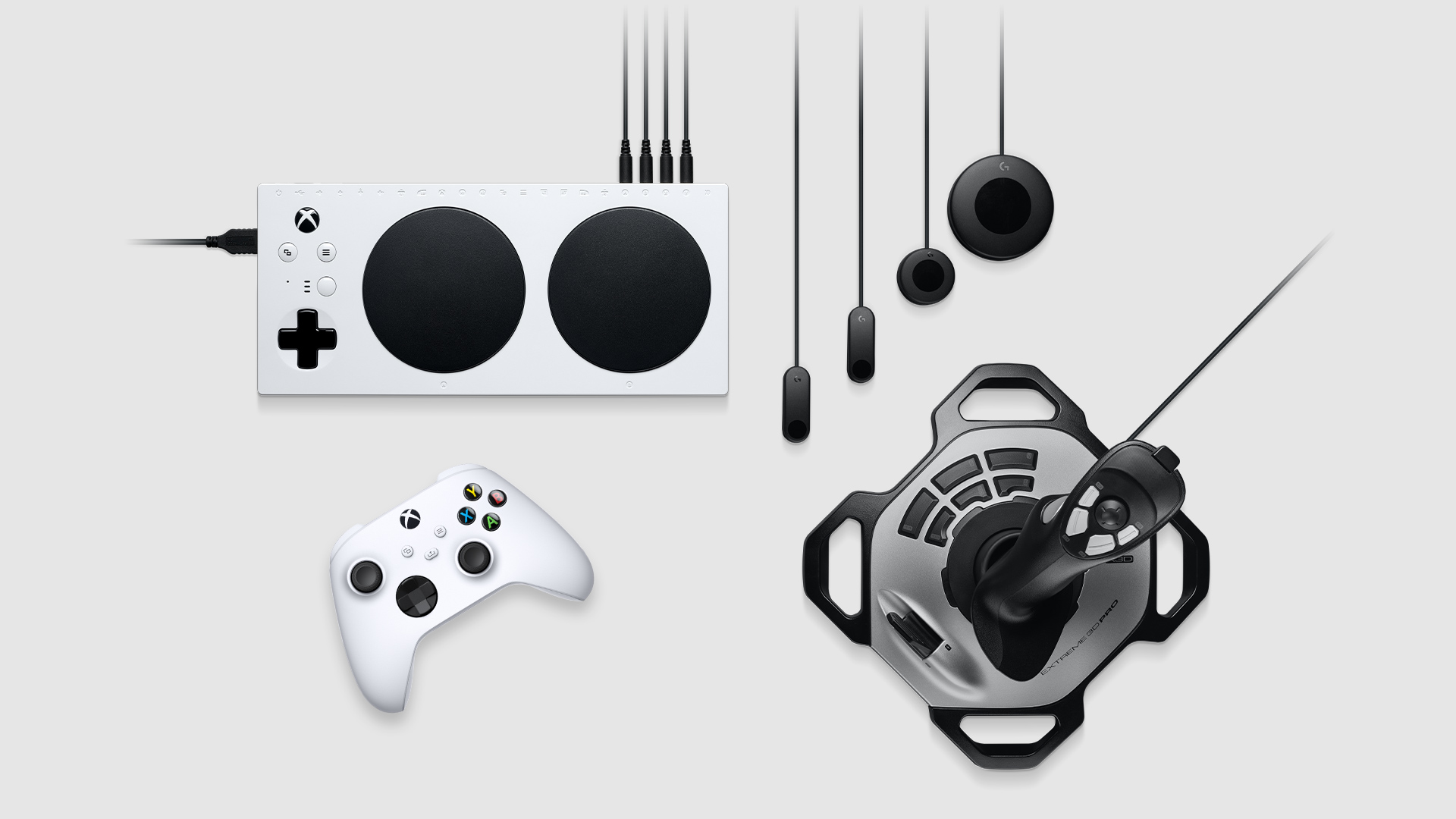 Collection of assistive accessories including Xbox adaptive controller, Logitech Adaptive Gaming Kit for Xbox adaptive controller, Xbox wireless controller, and Logitech Extreme 3D Pro Joystick. 