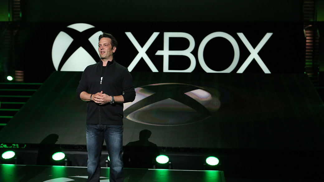 Phil Spencer, az Xbox vezetője az Xbox logó előtt áll egy színpadon