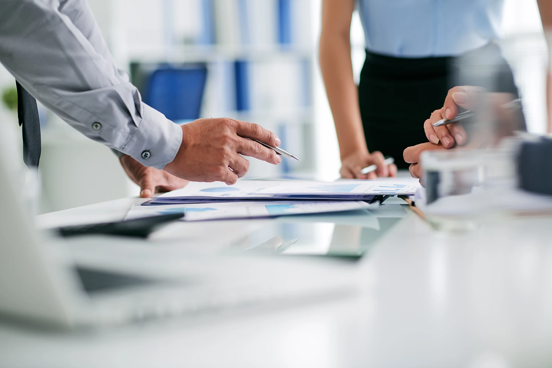 Business professionals handling documents at a table during a leadership meeting.