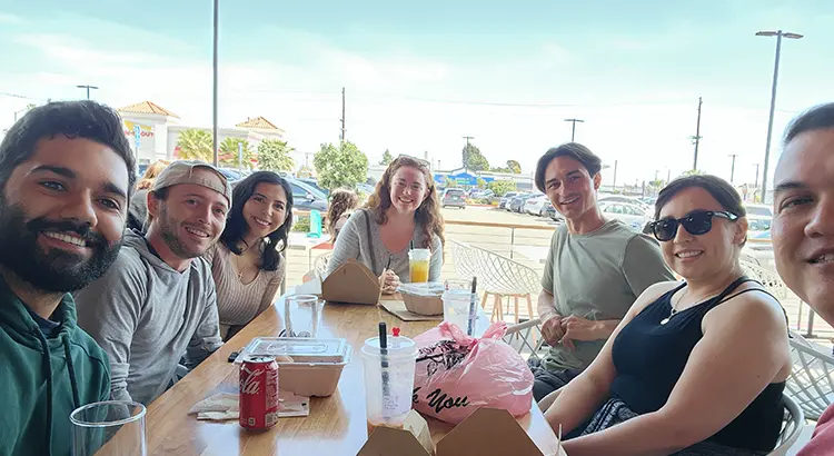 Apex Companies team members enjoying a meal outside on a sunny day