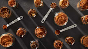 overhead view of various teaspoons and open jar filled with cinnamon