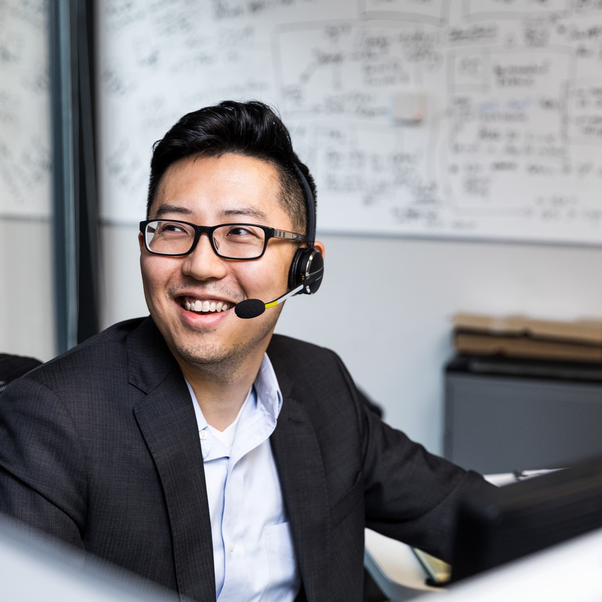 developer wearing glasses and smiling at camera