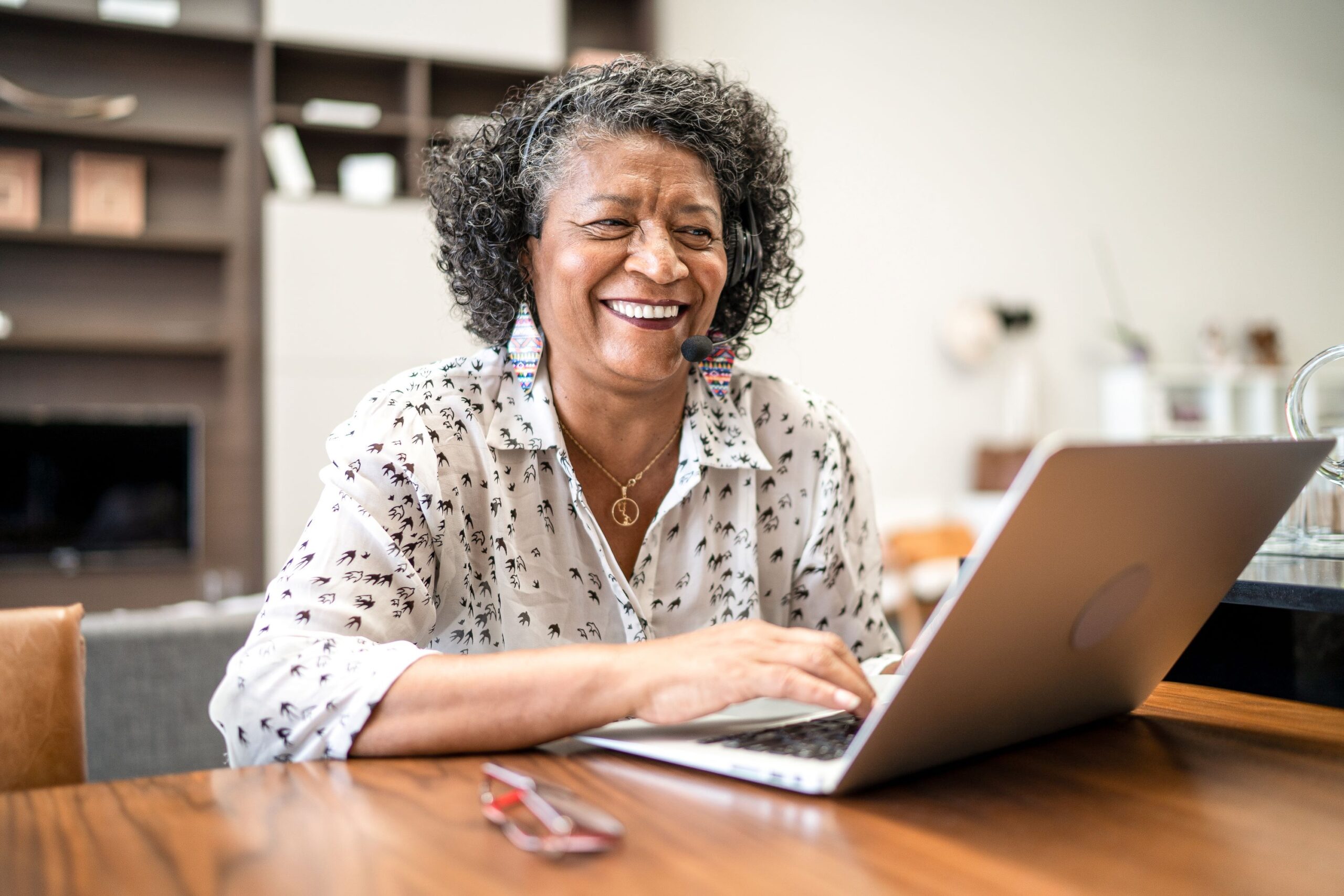 a person sitting at a table using a laptop computer