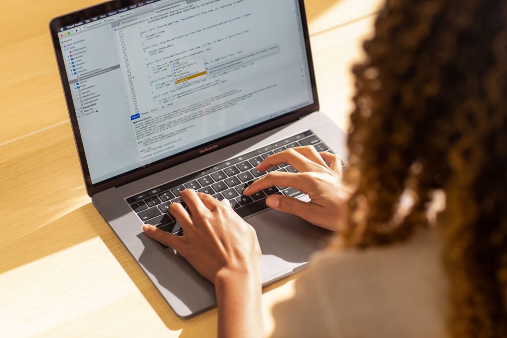 a person using a laptop computer sitting on top of a desk