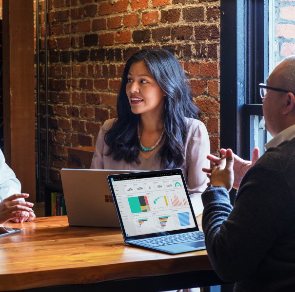 A group of people sitting at a table with laptops