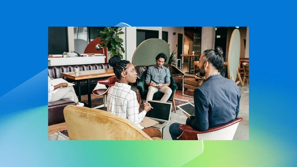 a group of employees meeting around a computer