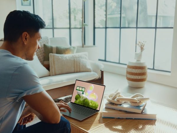 Man sitting on a couch looking down on laptop on a table