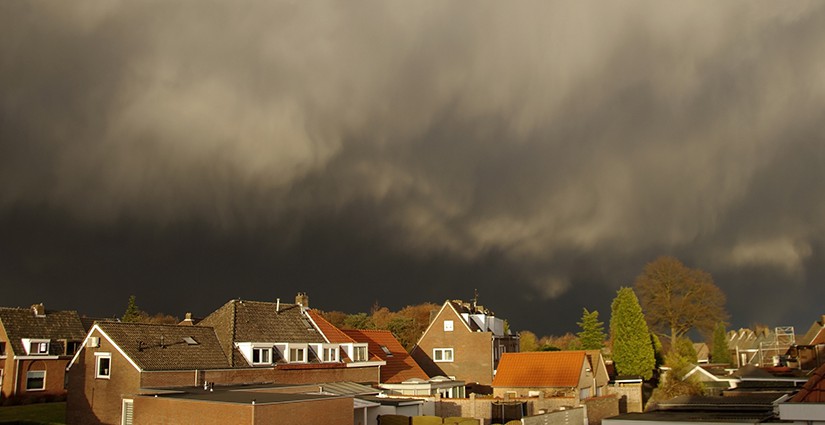 Dramatic sky in contrast with the afternoon sun on a November afternoon in Limburg, the Netherlands